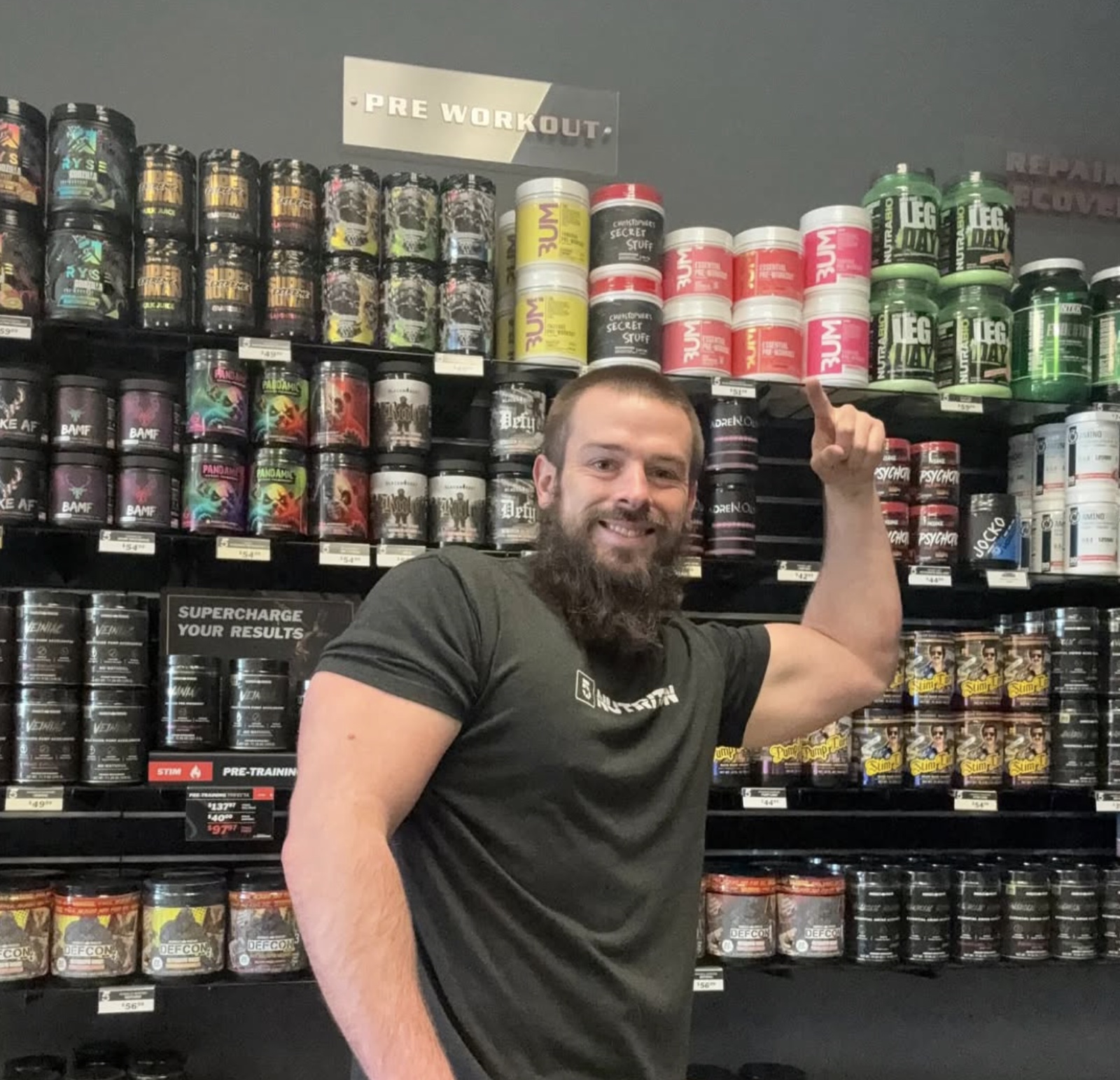 5 Star employee posing with shelves filled with products