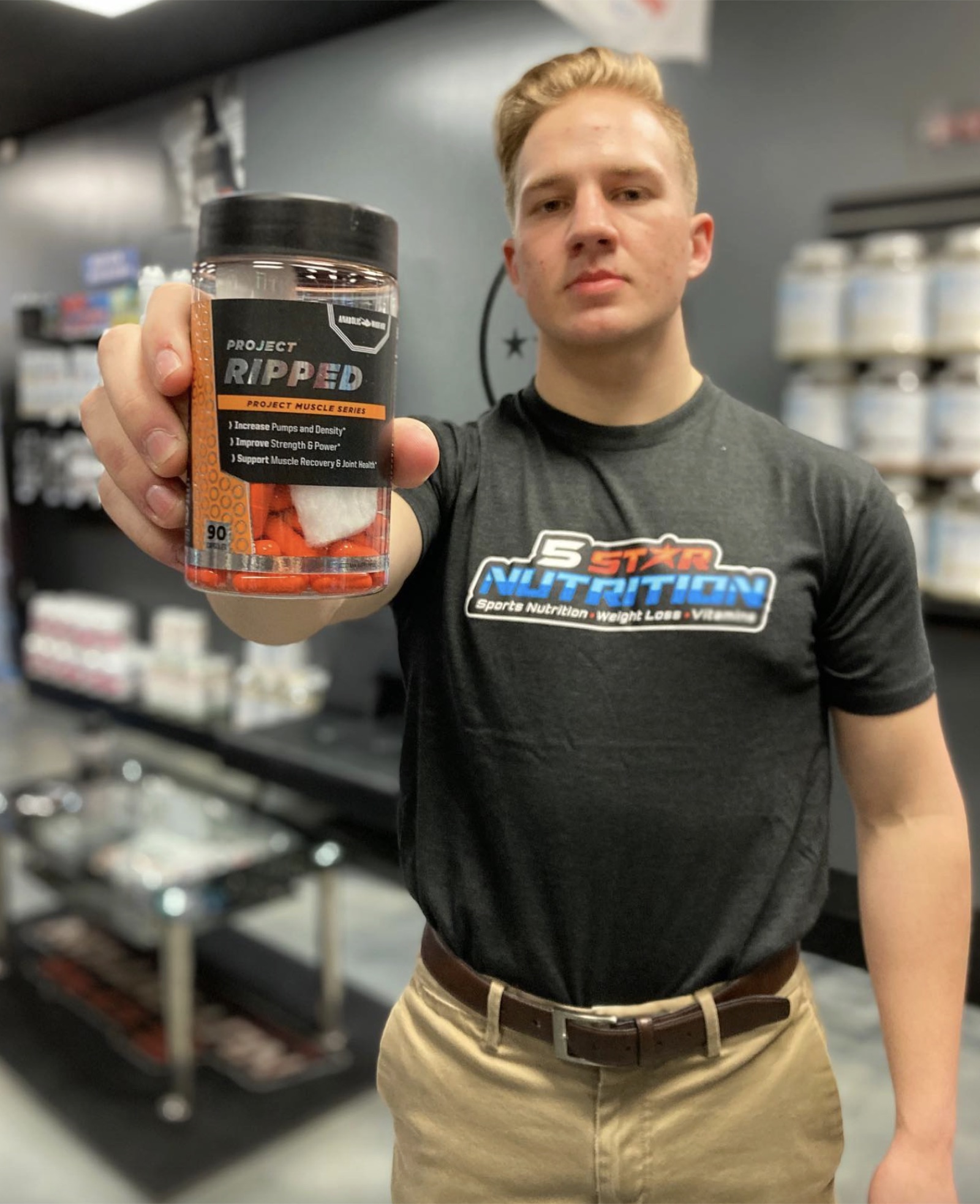 5 Star team member holding up a supplement bottle