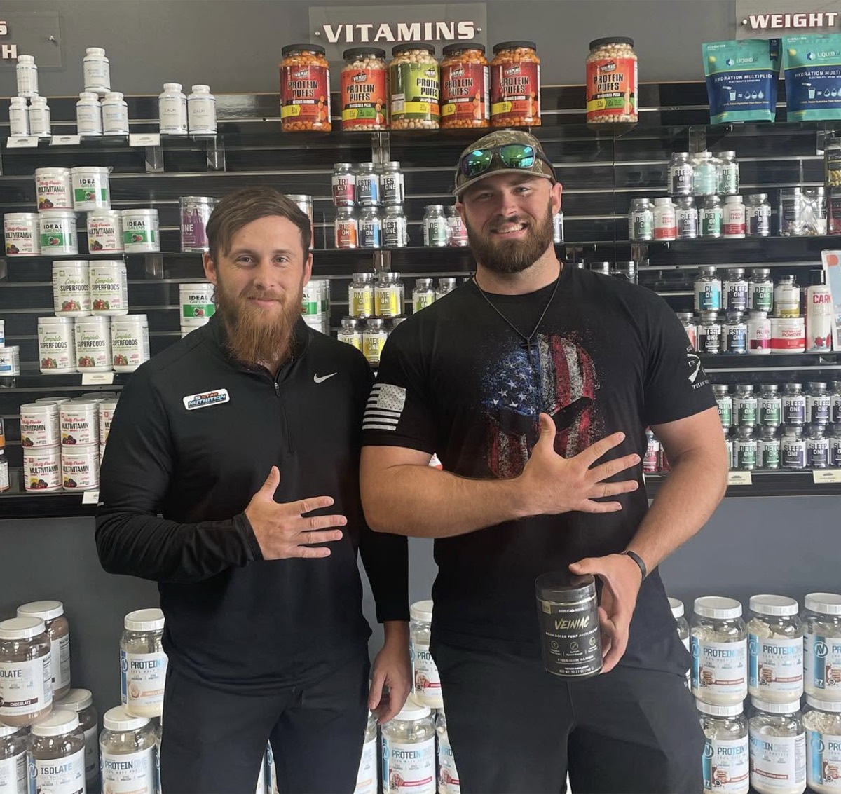 5 Star employee and customer posing together in front of a wall of products